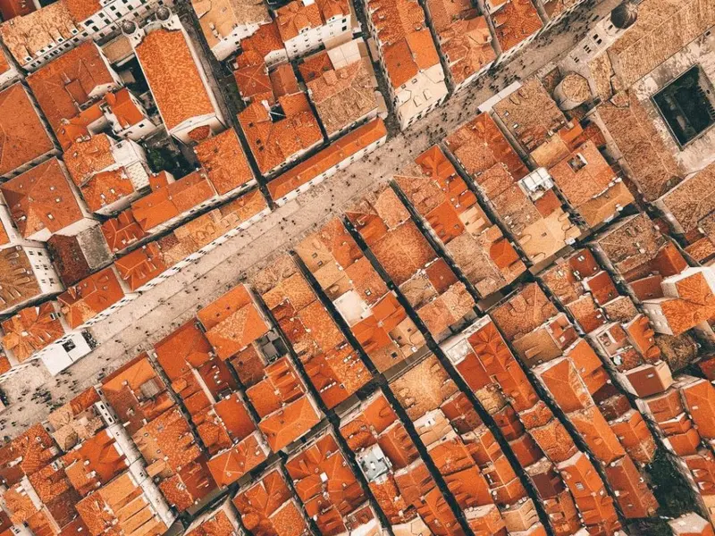 Aerial drone view of Stradun cutting through Dubrovnik Old Town.