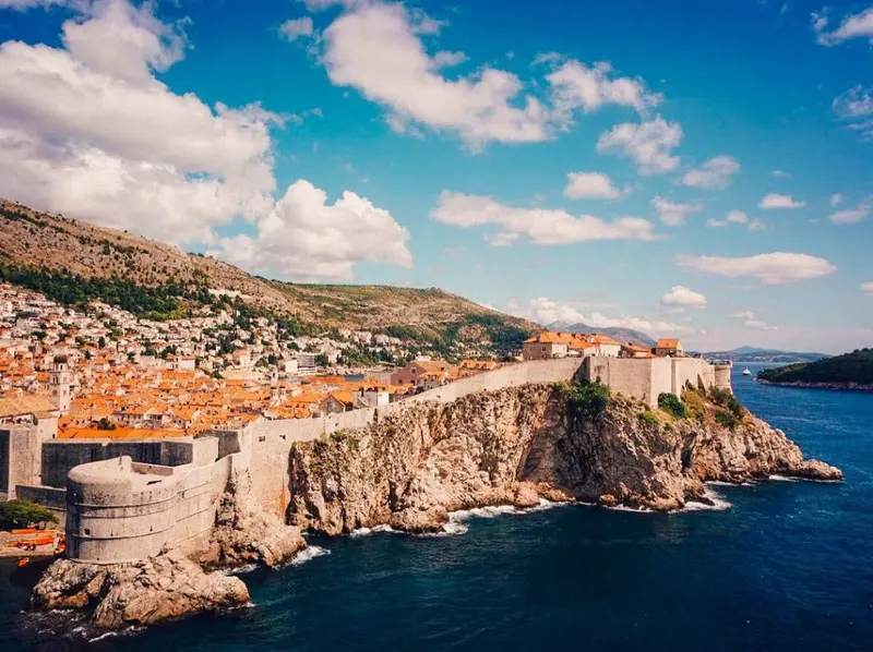 Close view of Dubrovnik's stone city walls with towers and battlements.
