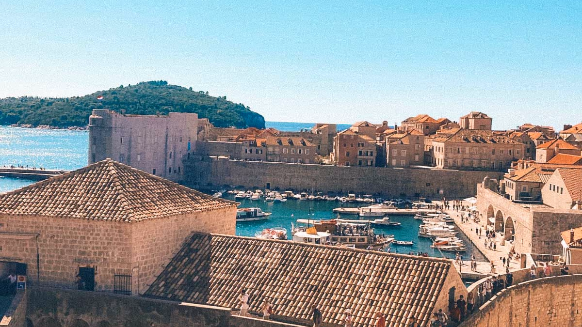 Dubrovnik Old Port and City Walls with boats and fortifications under a clear sky