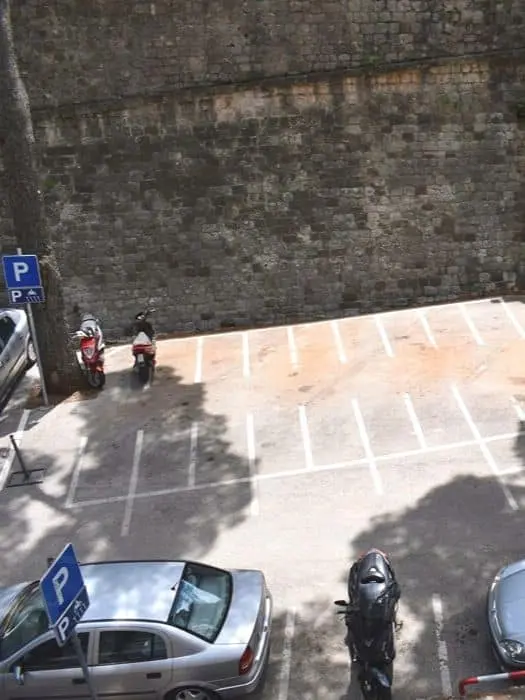 Empty scooter parking lot next to city walls
