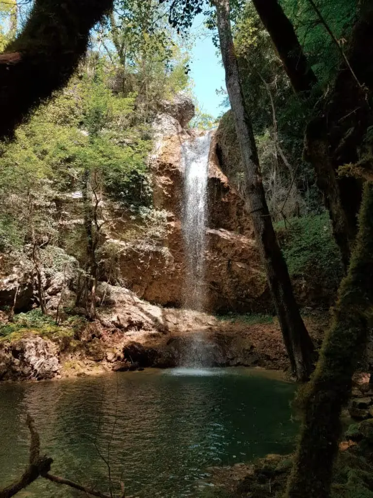 Butori Ponor waterfall emptying into a pool and disappearing underground.