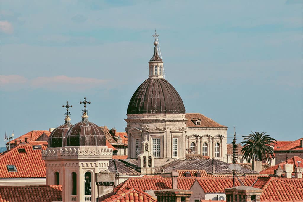Aerial view of Dubrovnik Cathedral dome surrounded by red rooftops.