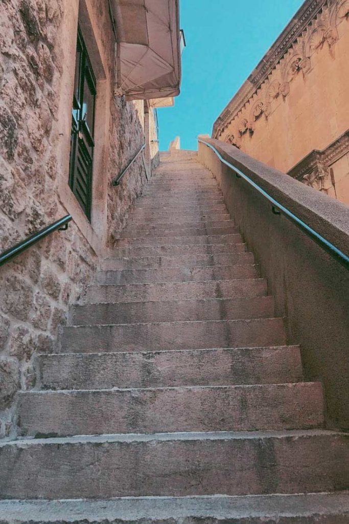 Steep stone staircase leading up to Dubrovnik City Walls at Pile Gate.